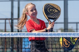 Meisje met padelracket aan het net Meisje met padelracket aan het net
